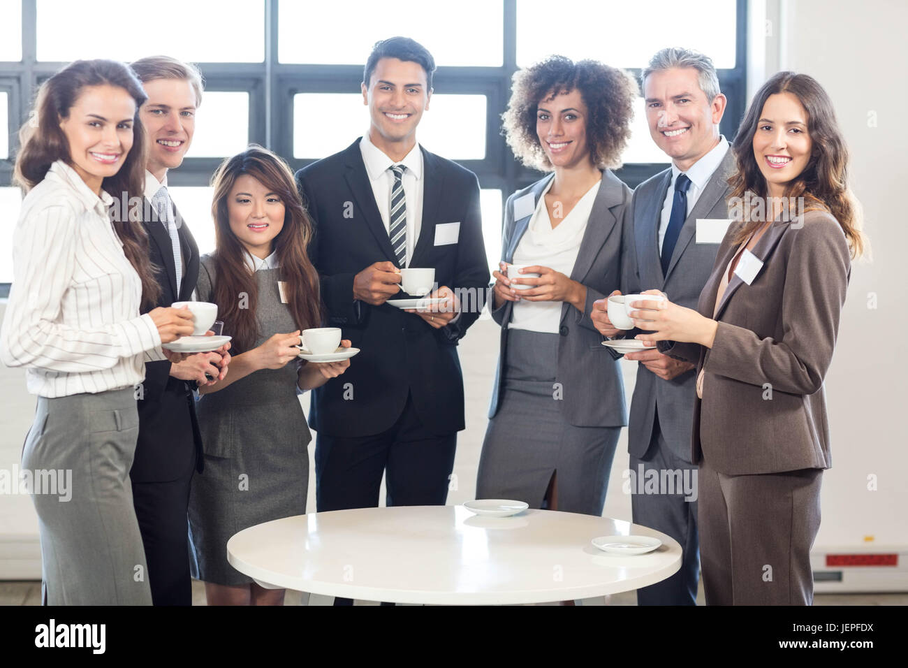 Businesspeople standing together in office Stock Photo - Alamy