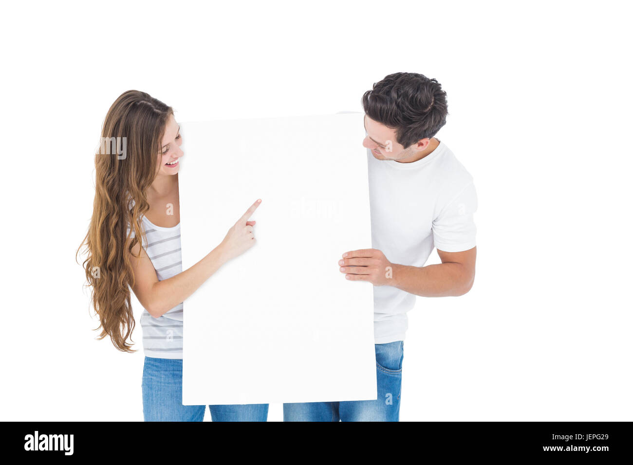Happy couple pointing a white poster Stock Photo - Alamy