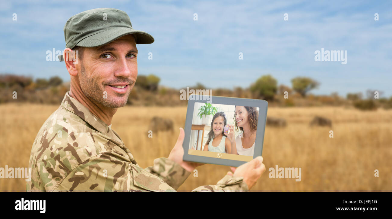 Composite image of soldier using tablet pc Stock Photo