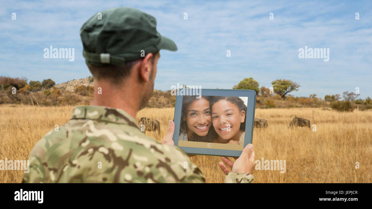 Composite image of soldier using tablet pc Stock Photo