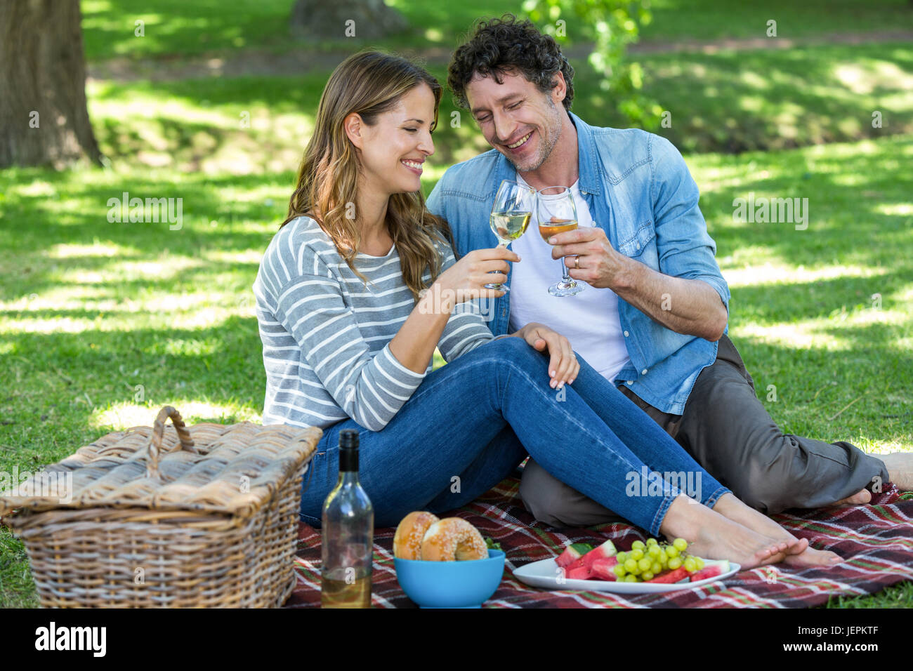Couple having a picnic with wine Stock Photo - Alamy