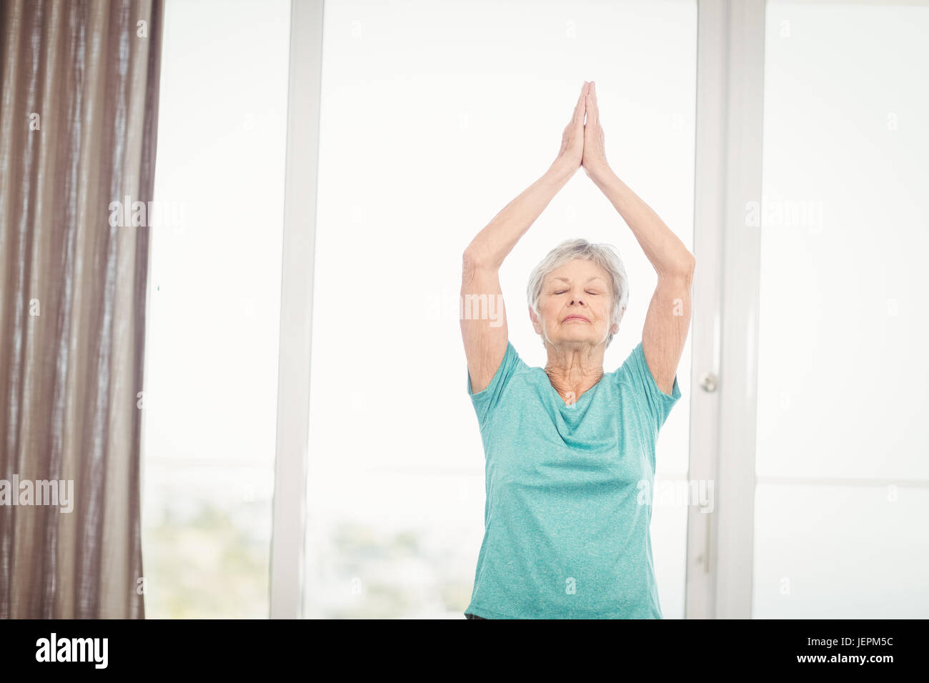 Senior woman performing yoga Stock Photo - Alamy