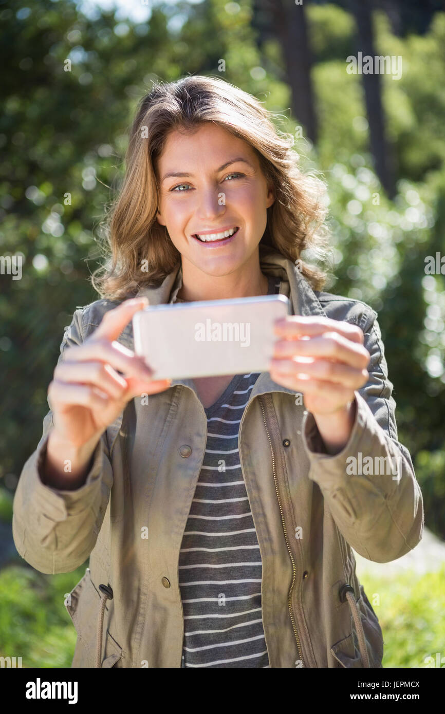 Smiling woman taking selfie Stock Photo - Alamy