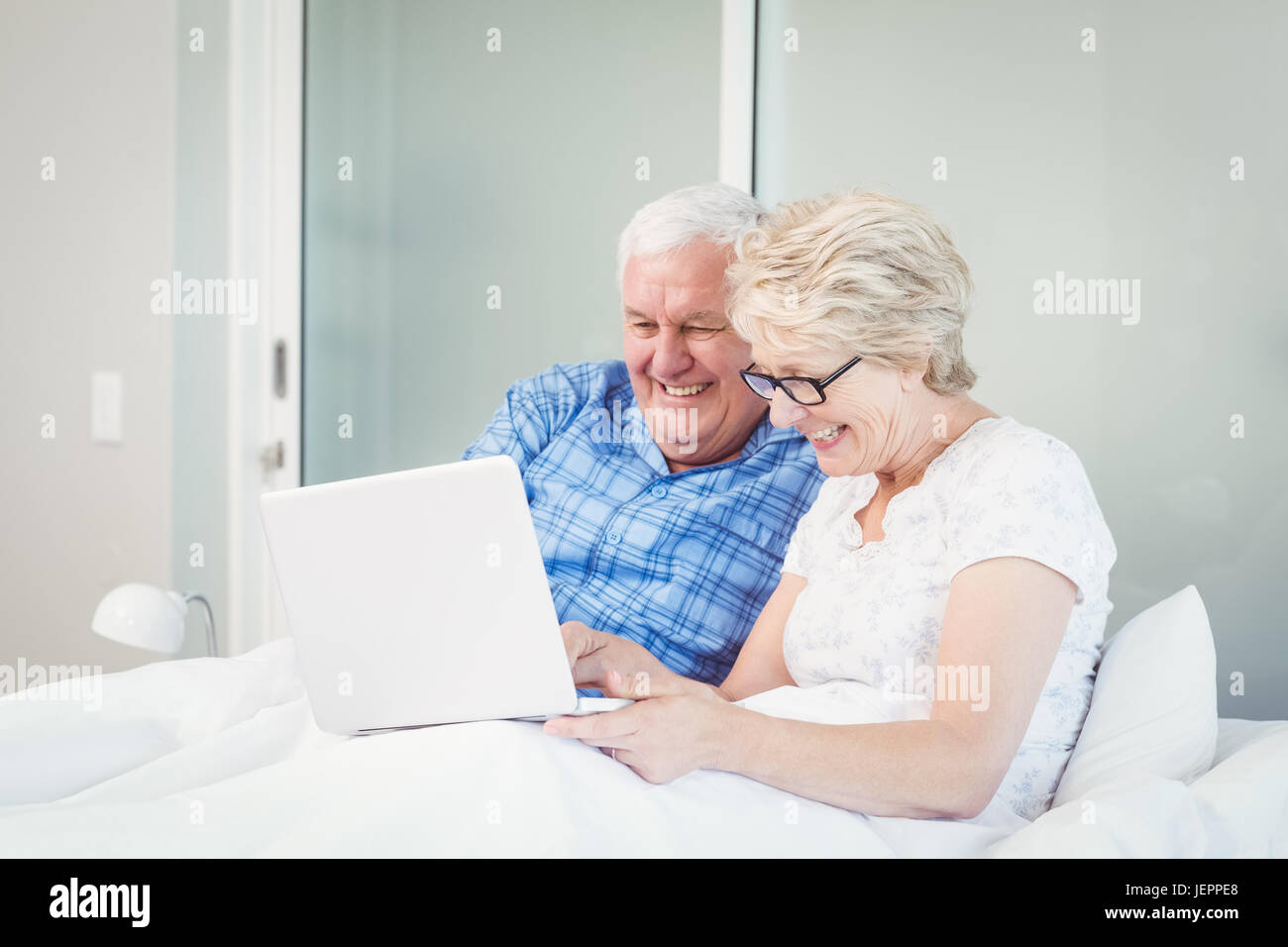 Happy couple using laptop at home Stock Photo - Alamy