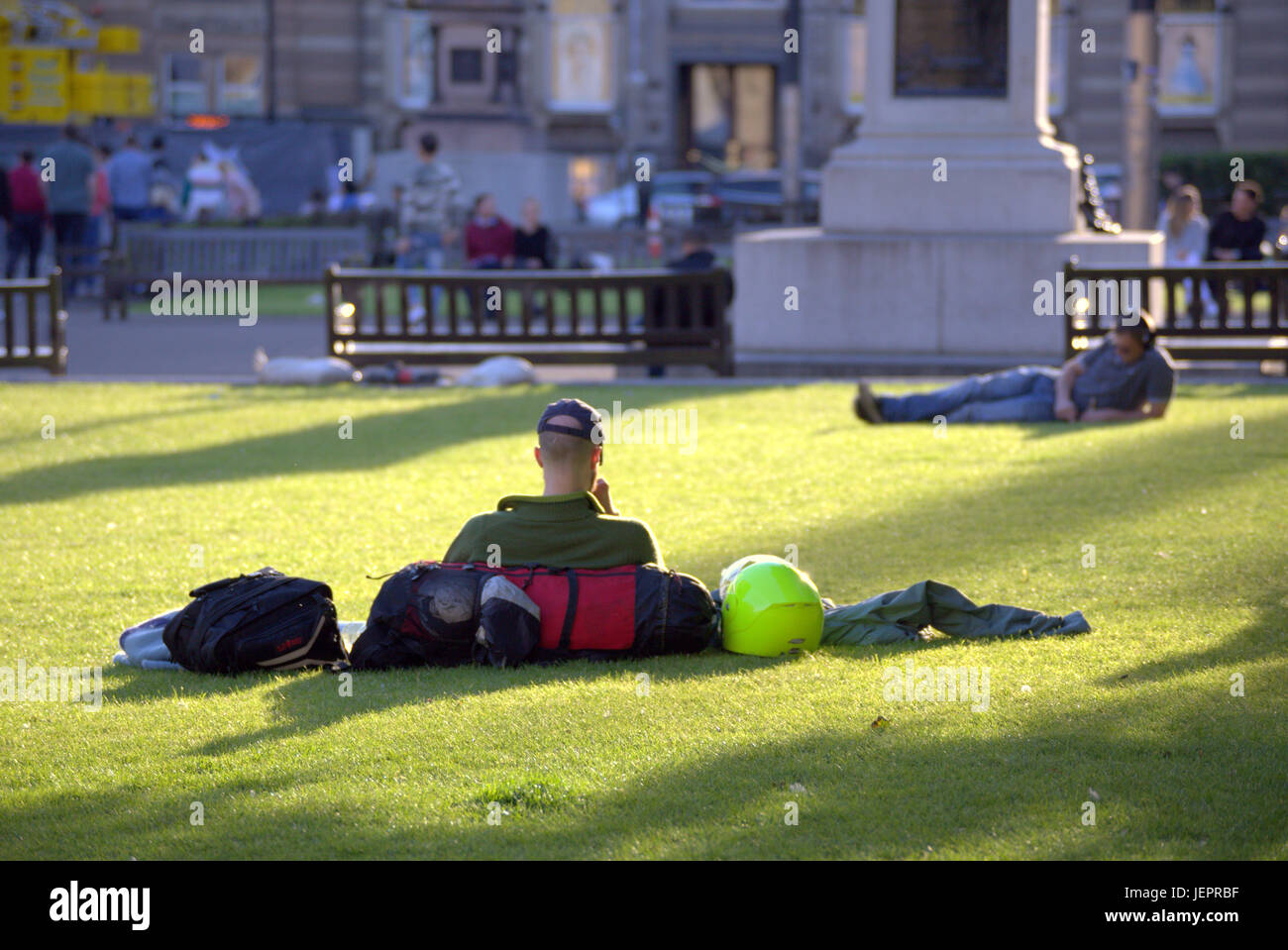 Summer weather returns and people enjoy the summer on the streets , George Square , Scotland   tourist catches some of the sunny weather Stock Photo