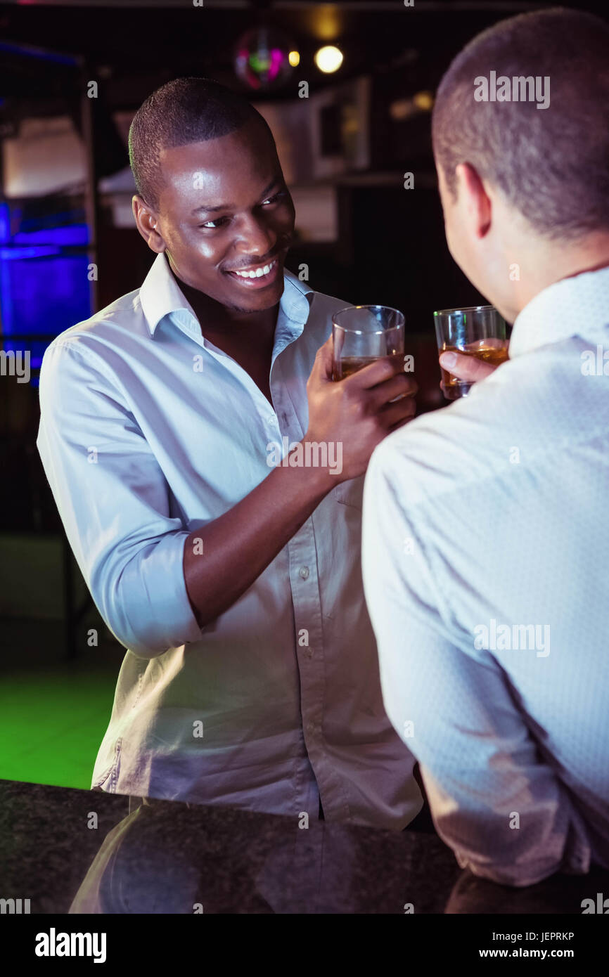 Two men toasting with glass of whiskey Stock Photo