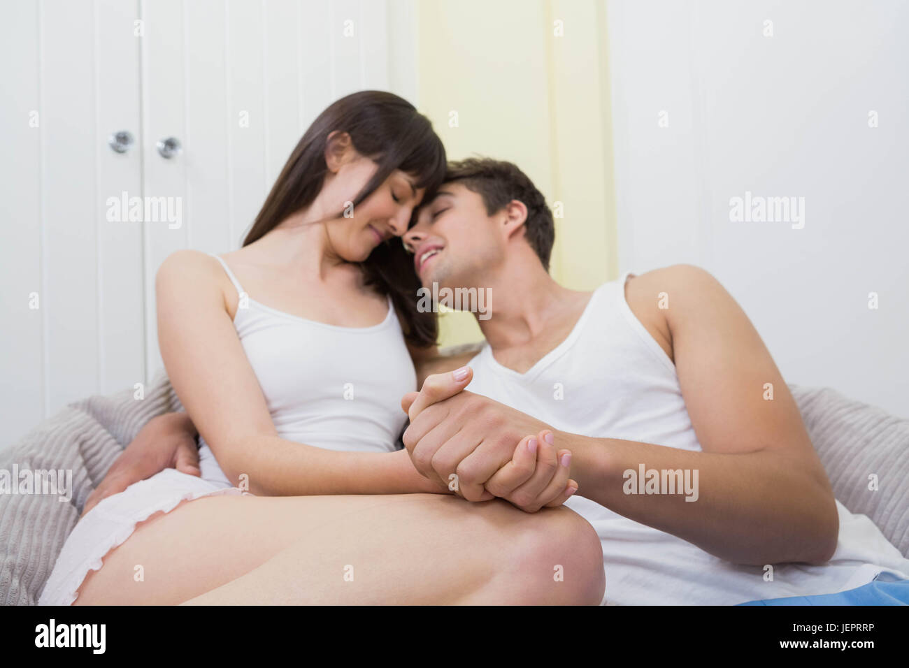 Young couple cuddling on sofa Stock Photo
