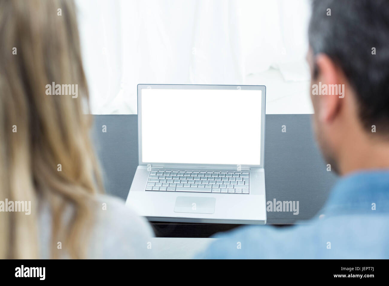 Couple using laptop in living room Stock Photo - Alamy