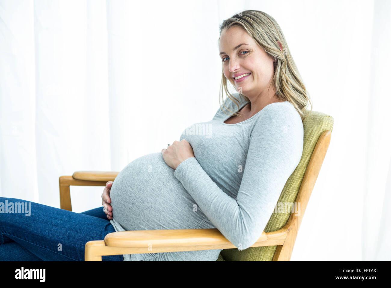 Pregnant woman holding her stomach Stock Photo - Alamy