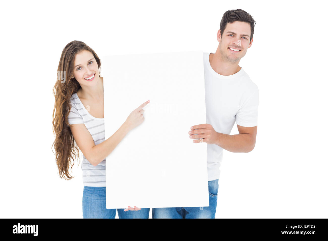 Happy couple pointing a white poster Stock Photo - Alamy