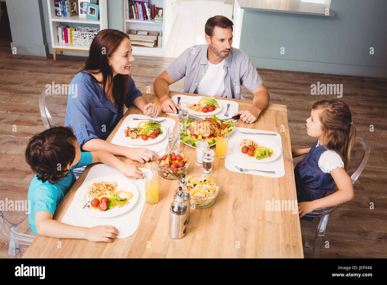 Family discussing with food on dining table Stock Photo