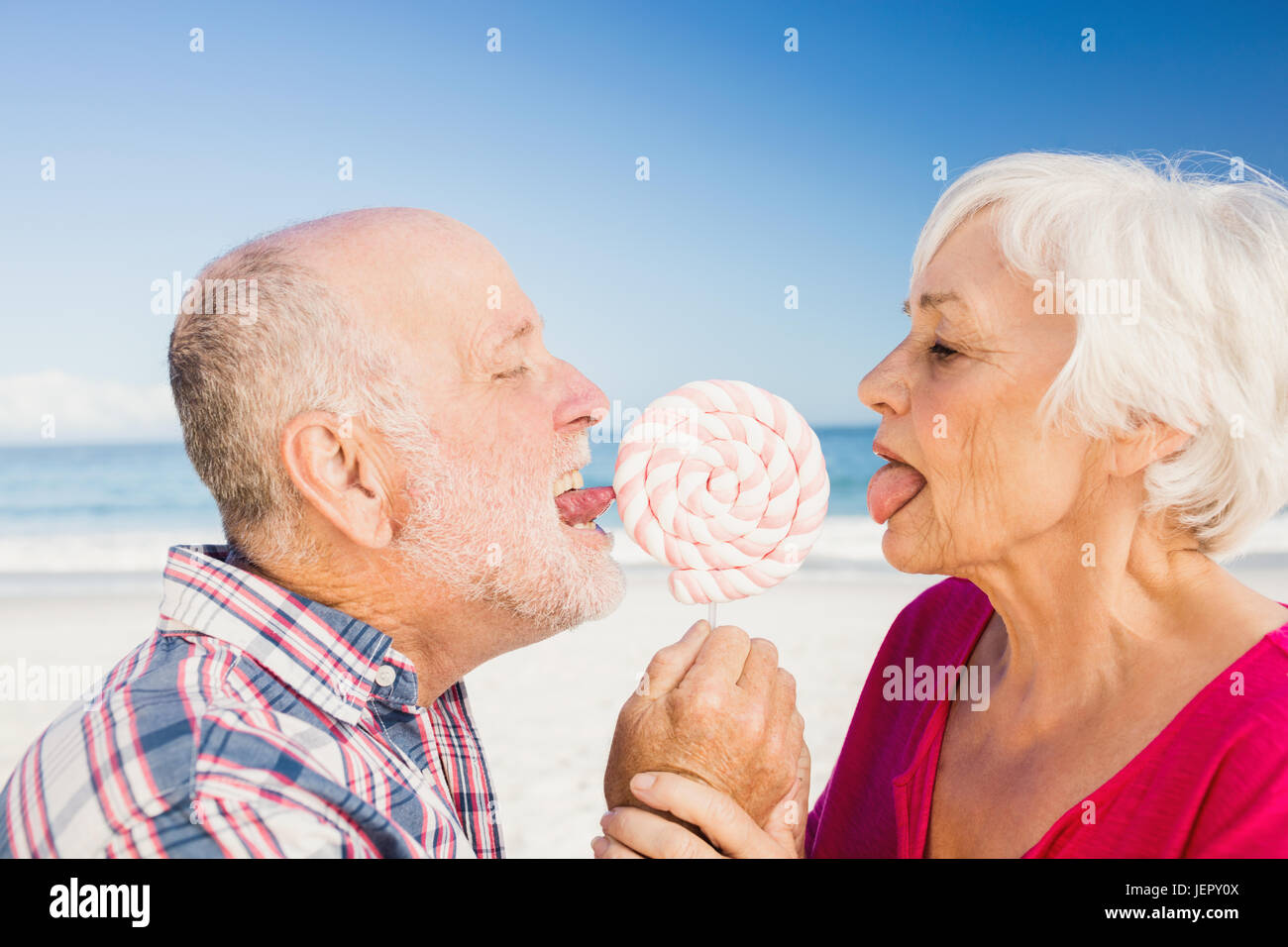 Senior couple licking lollipop Stock Photo
