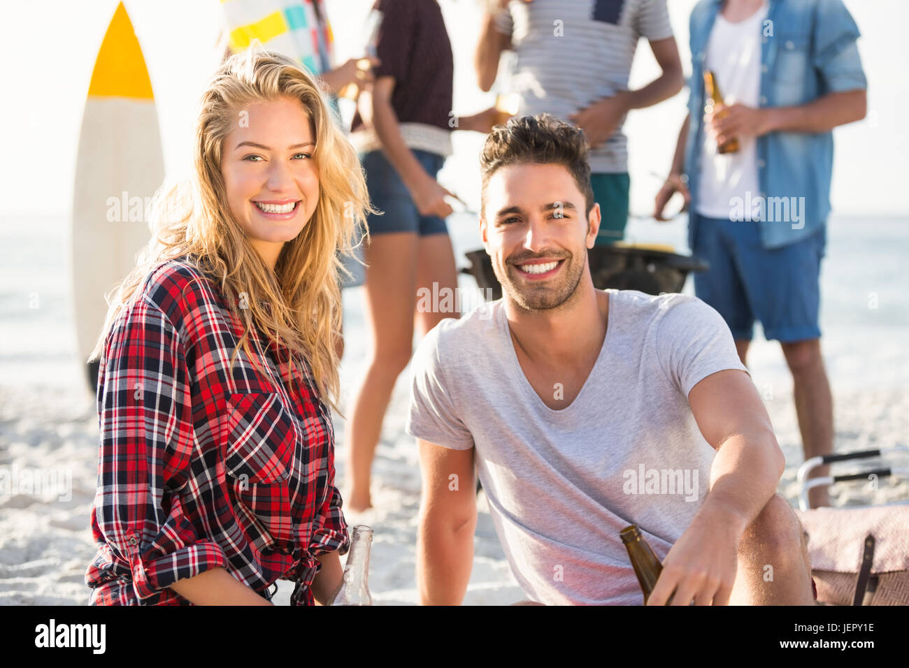 Couple sitting on sand at the beach Stock Photo - Alamy