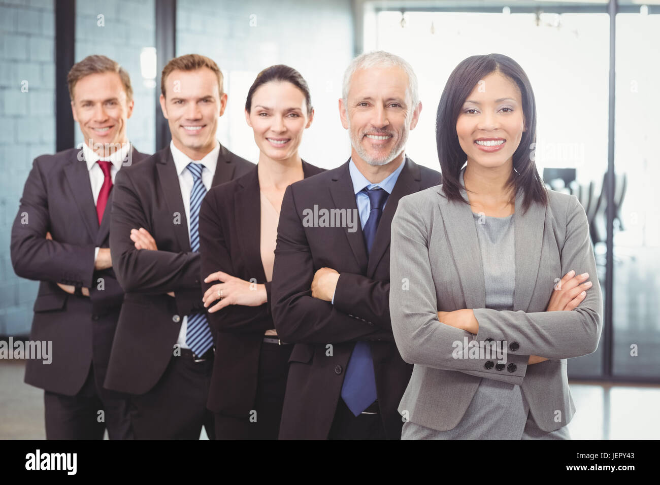 Businesspeople standing with arms crossed Stock Photo - Alamy