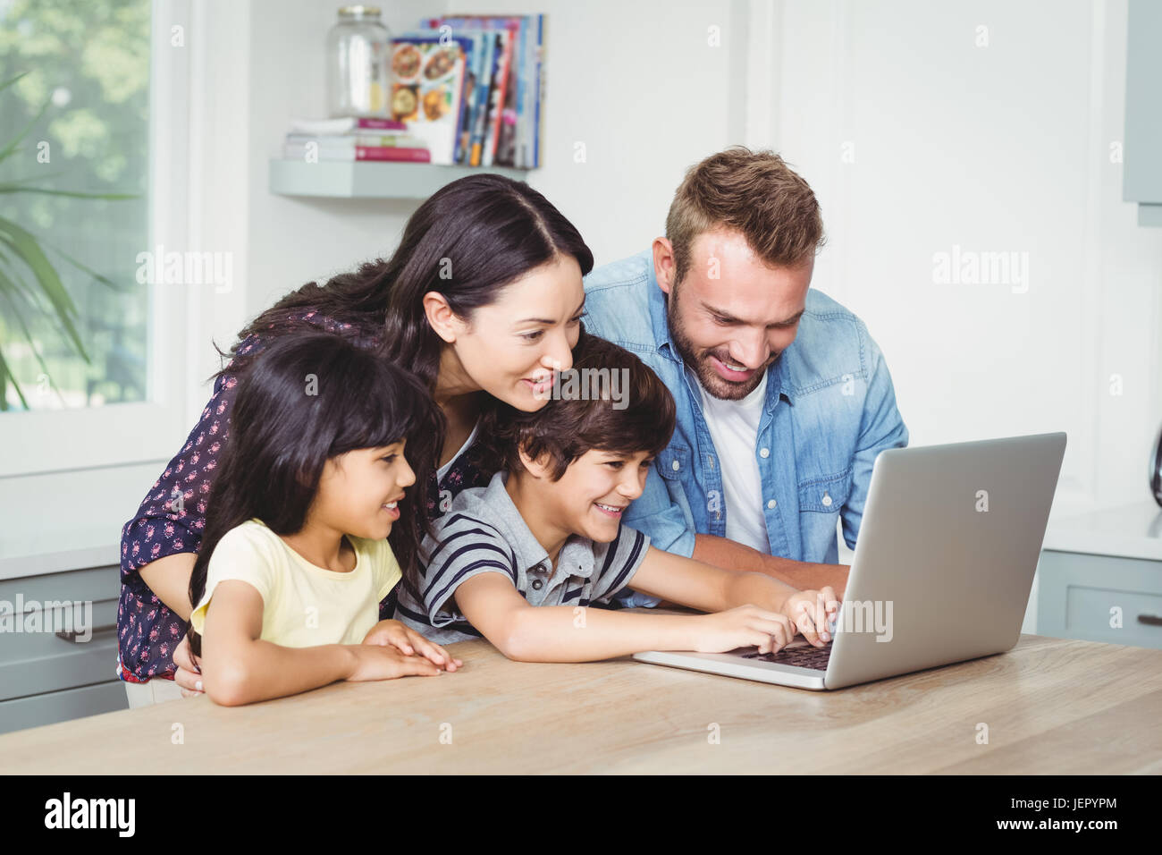 Smiling family using laptop Stock Photo - Alamy
