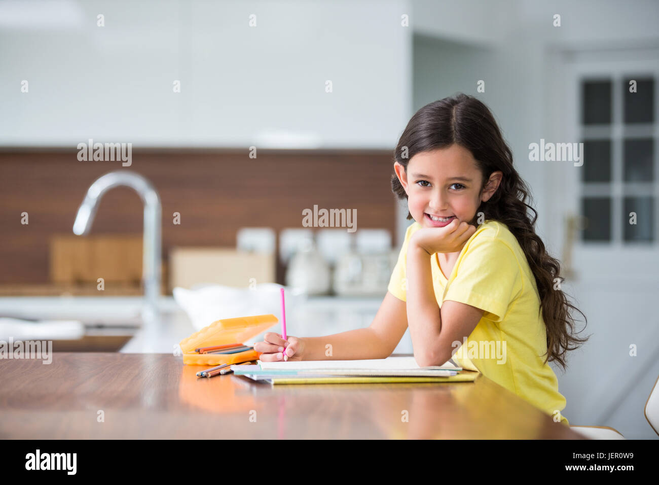 Portrait of smiling girl with hand on chin Stock Photo - Alamy