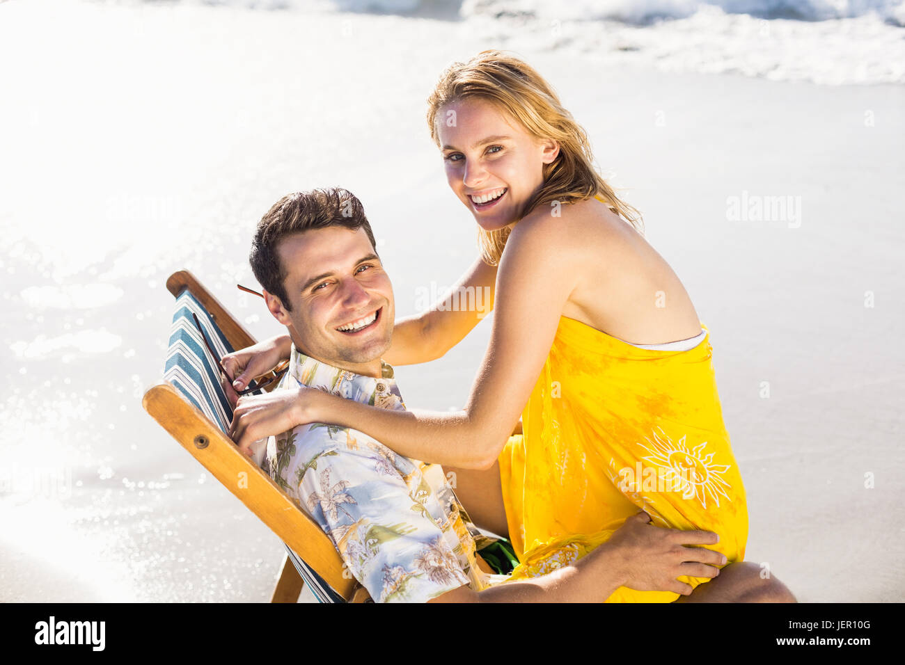 Woman sitting on mans lap at beach Stock Photo