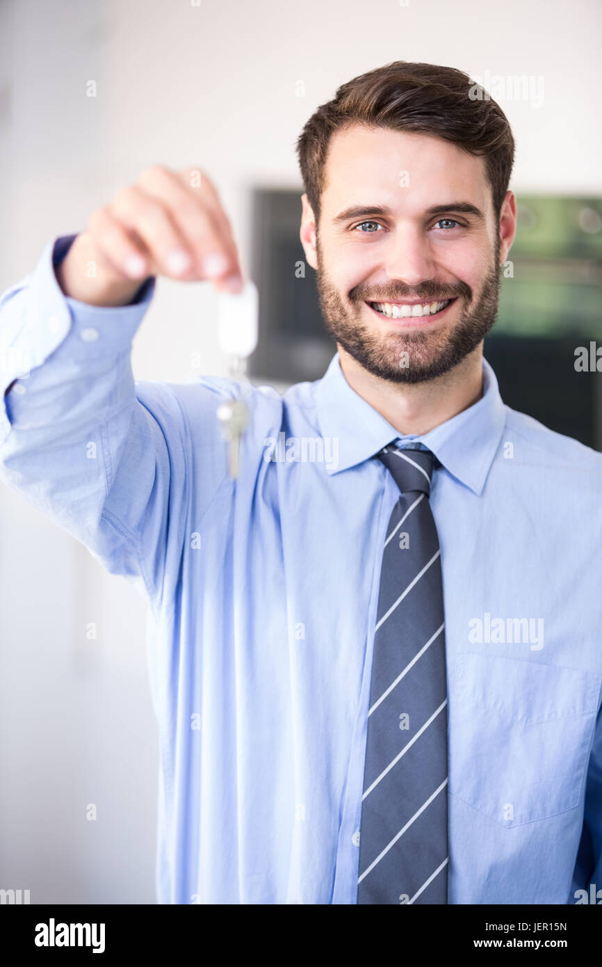 Businessman smiling while showing house keys Stock Photo Alamy