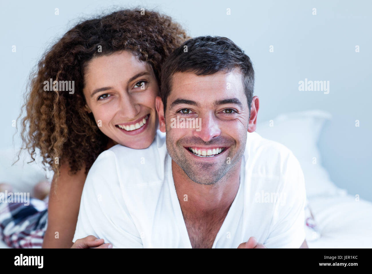 Portrait of happy couple lying on bed Stock Photo - Alamy