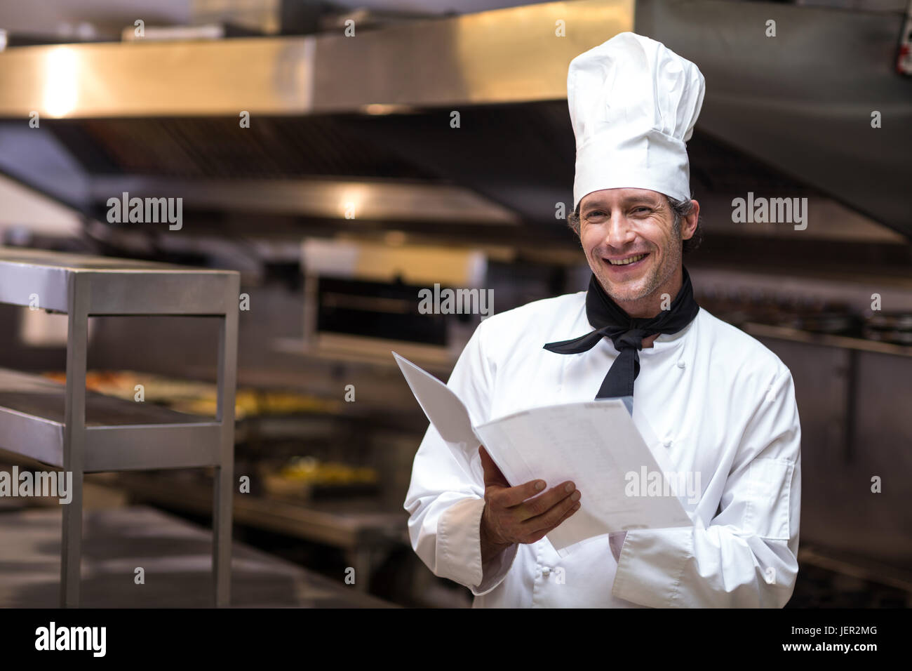 Handsome chef reading menu Stock Photo - Alamy