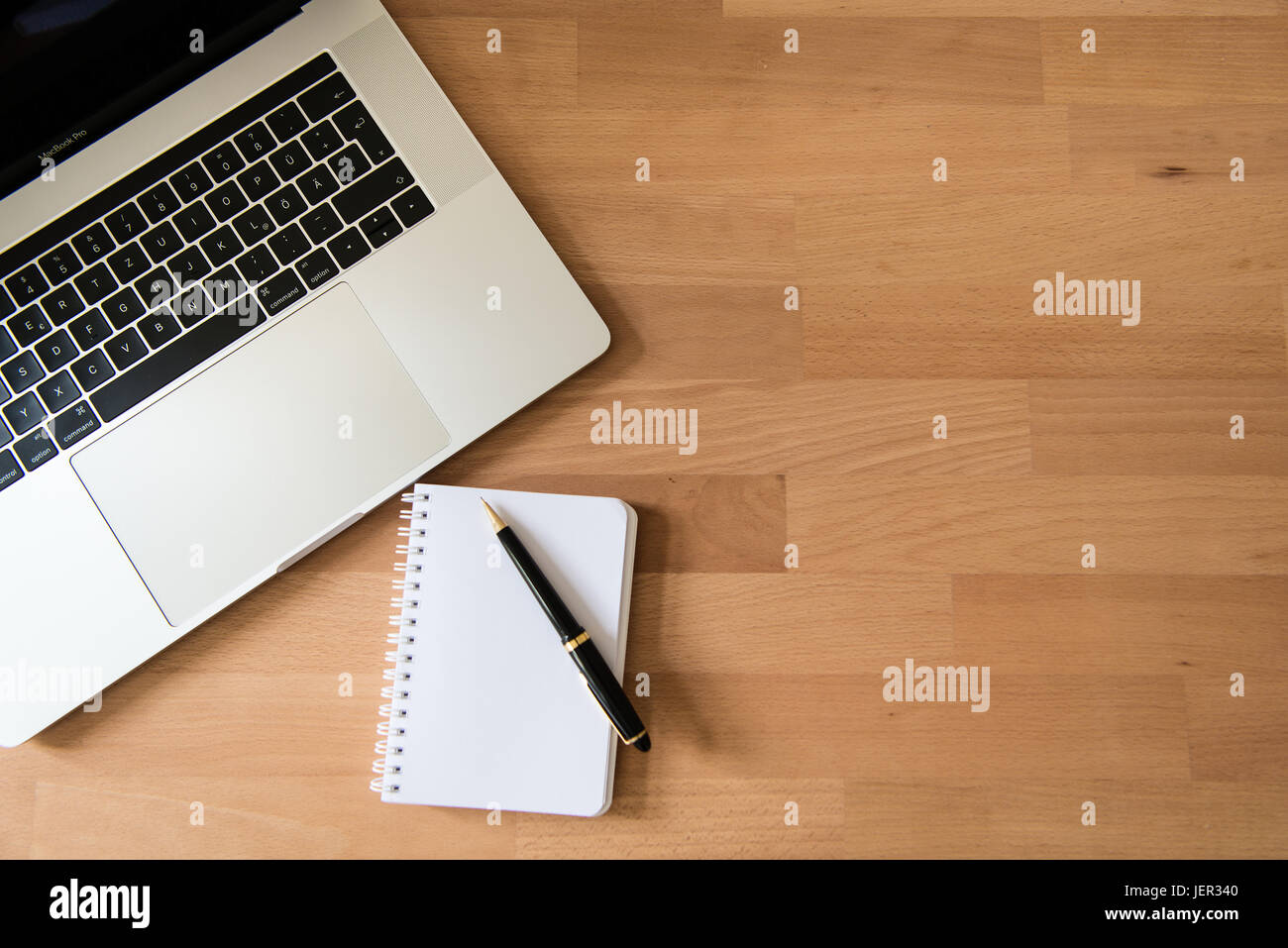 Laptop, Apple MacBook Pro with pen and notepad on desk Stock Photo - Alamy
