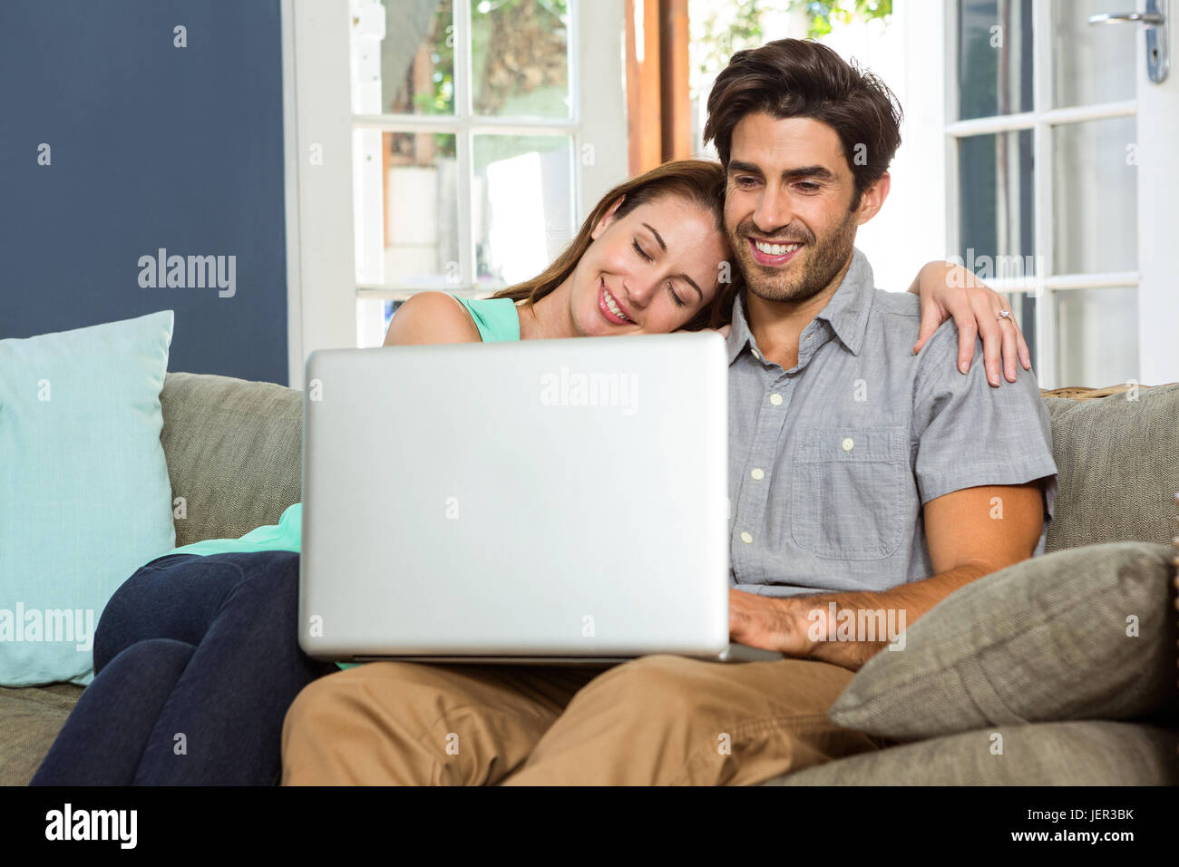 Happy young couple using laptop Stock Photo - Alamy