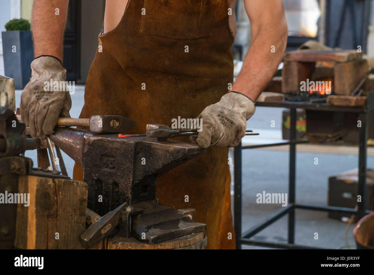 Blacksmith creating objects from wrought iron by forging the metal ...