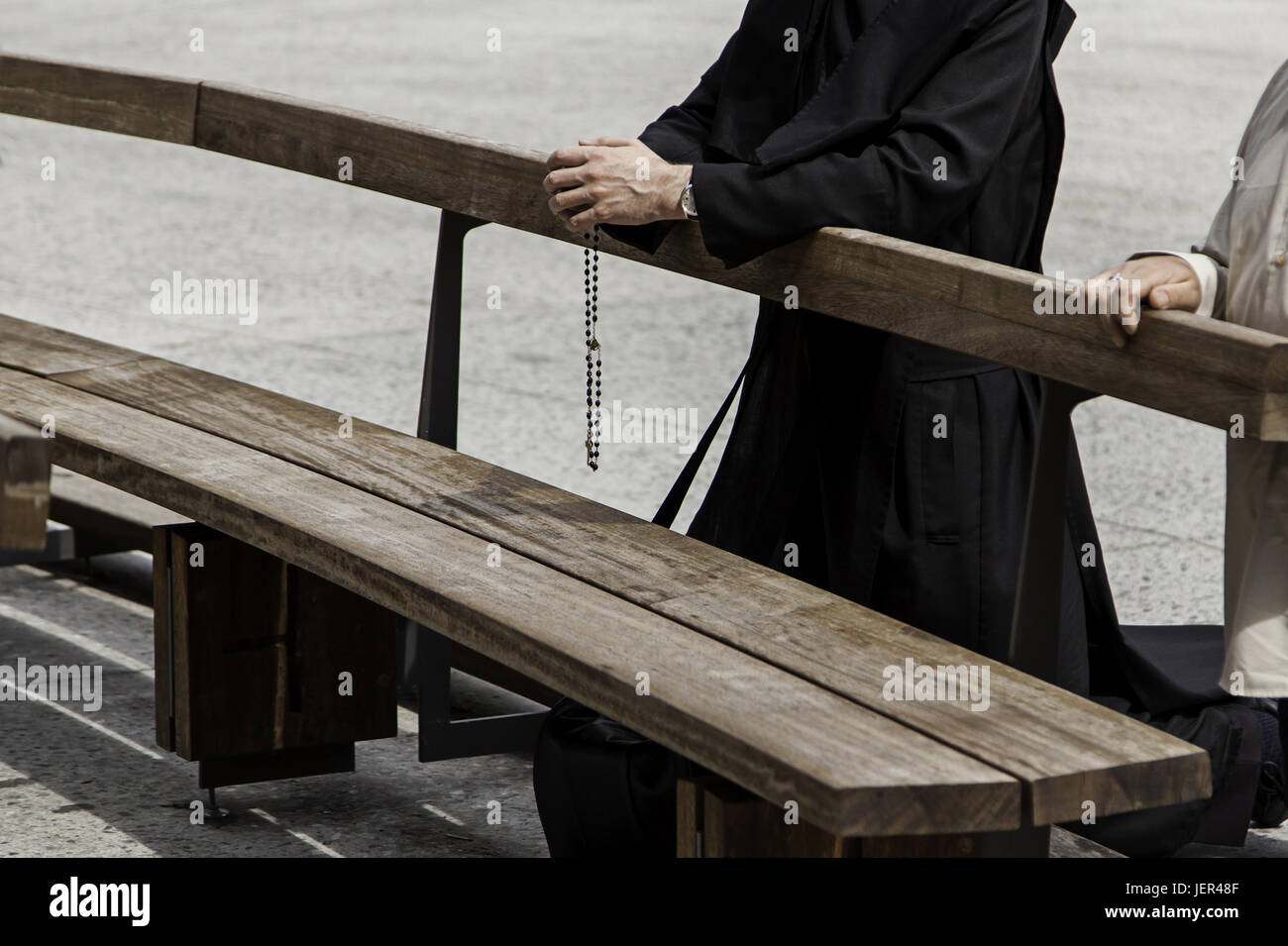 Hands of a priest with cross praying, detail of belief and Christian faith Stock Photo