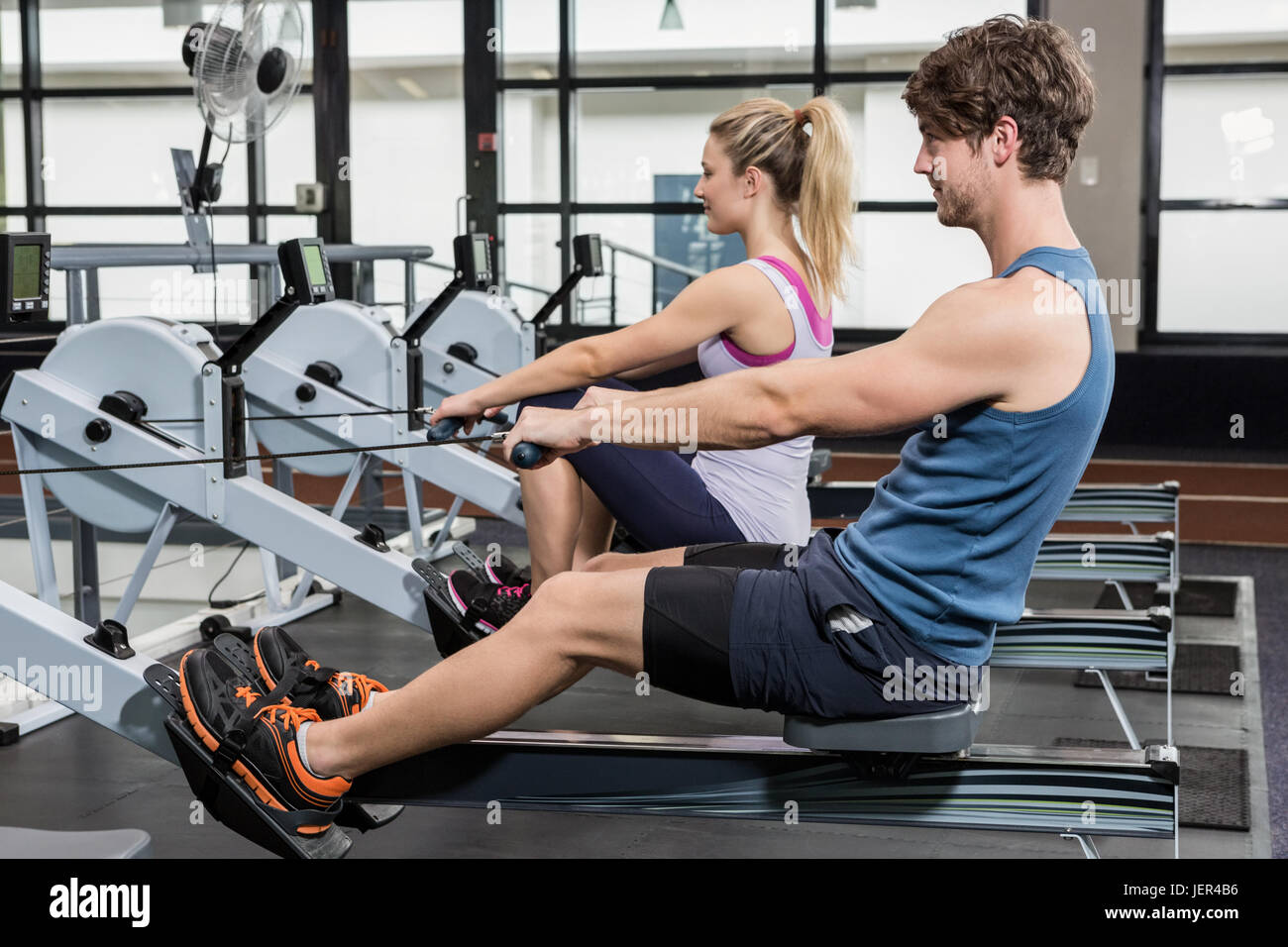 Man and woman working out on rowing machine Stock Photo