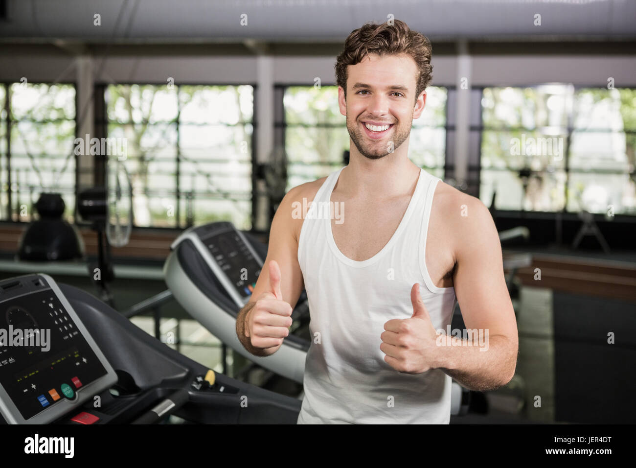 Happy man showing his thumbs up at gym Stock Photo - Alamy