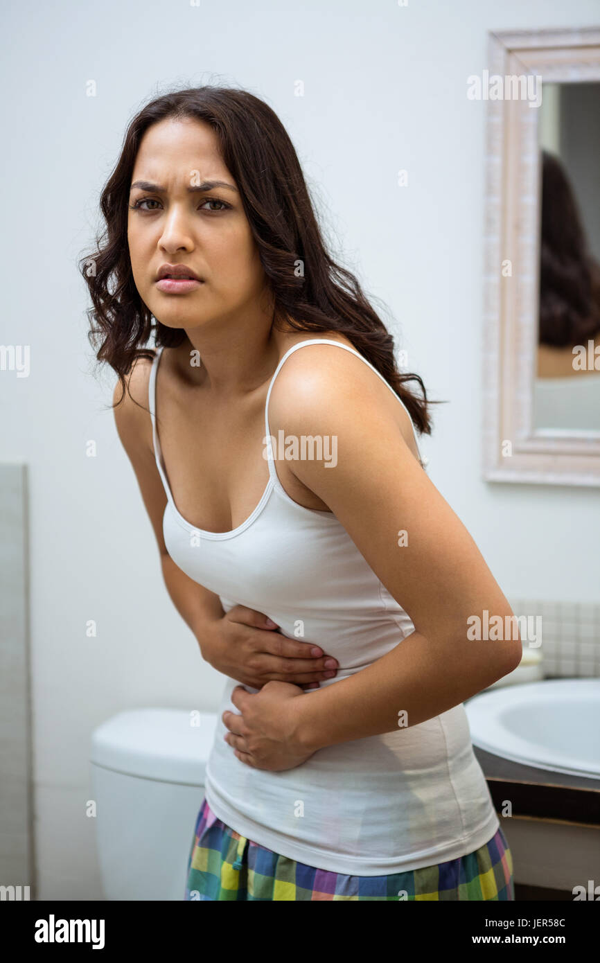 Young woman having stomach pain in bathroom Stock Photo Alamy