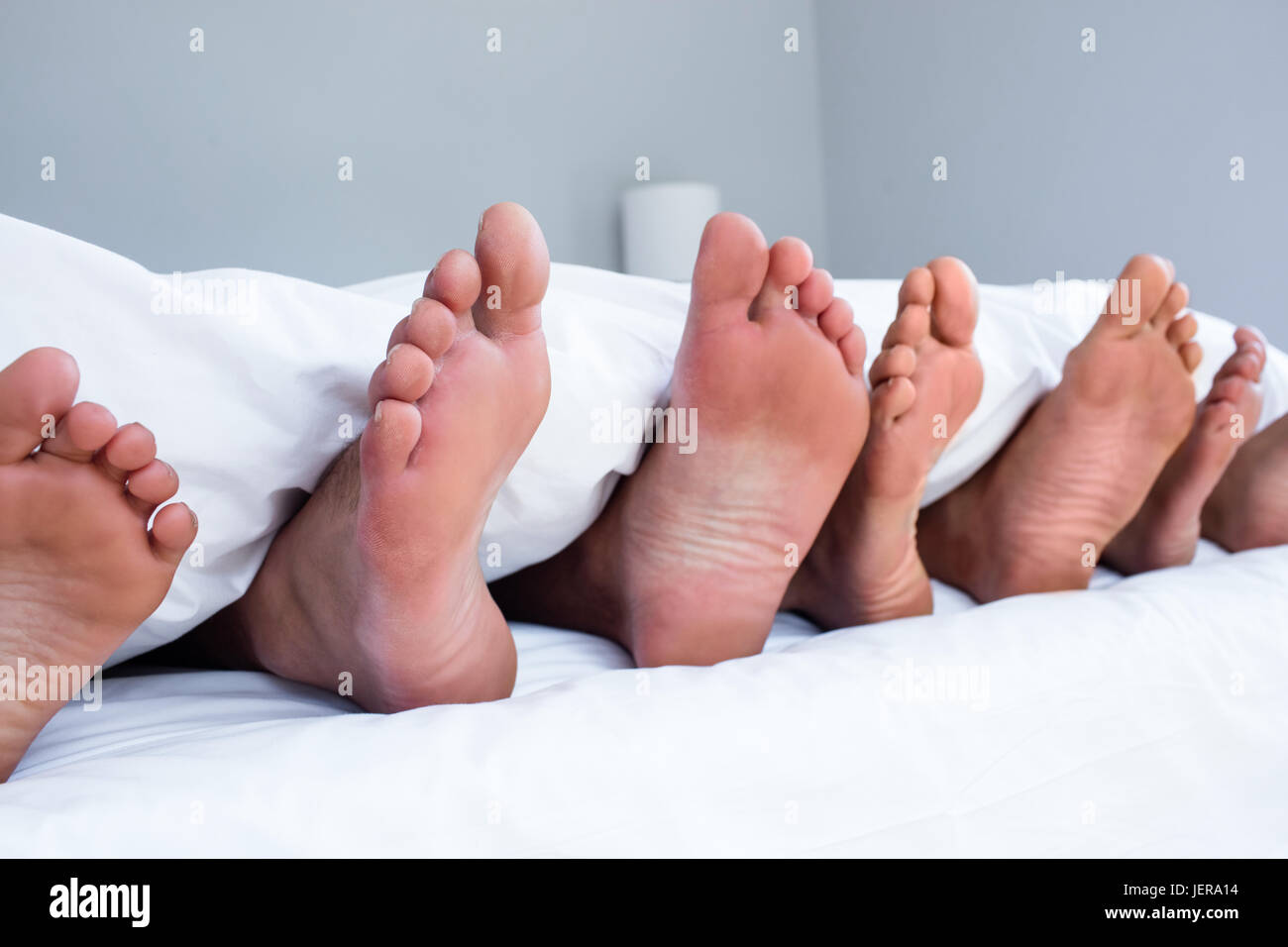 Три пары ног у. Три пары ног из под одеяла. Ноги семьи из под одеяла. Много ног из под одеяла. Ноги семьи под одеялом.