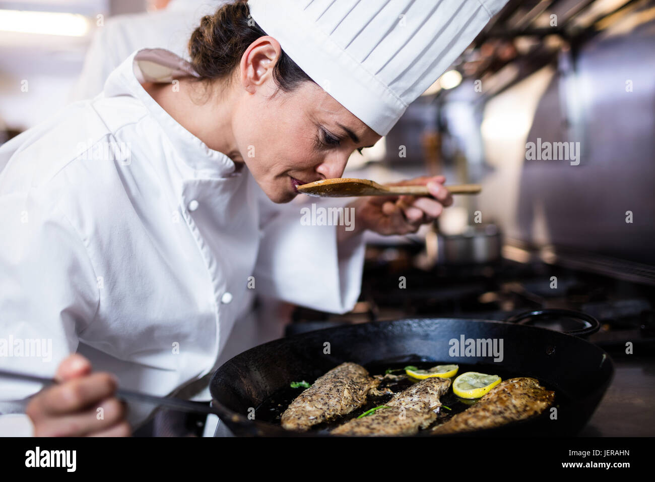 Chef smelling fried fish in the kitchen Stock Photo Alamy