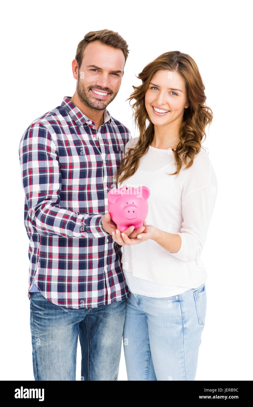 Happy young couple holding piggy bank Stock Photo - Alamy
