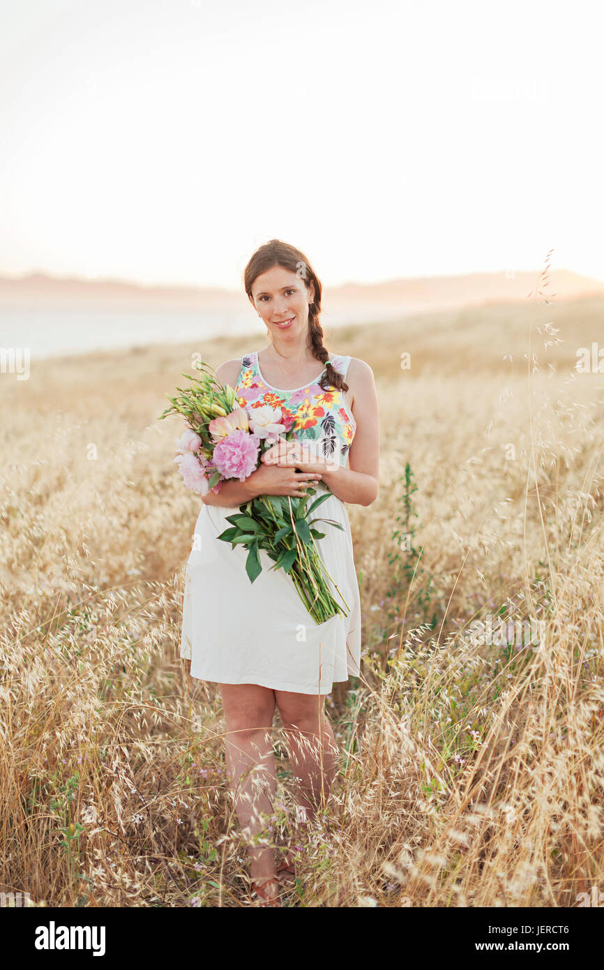 Woman with flowers in meadow Stock Photo - Alamy