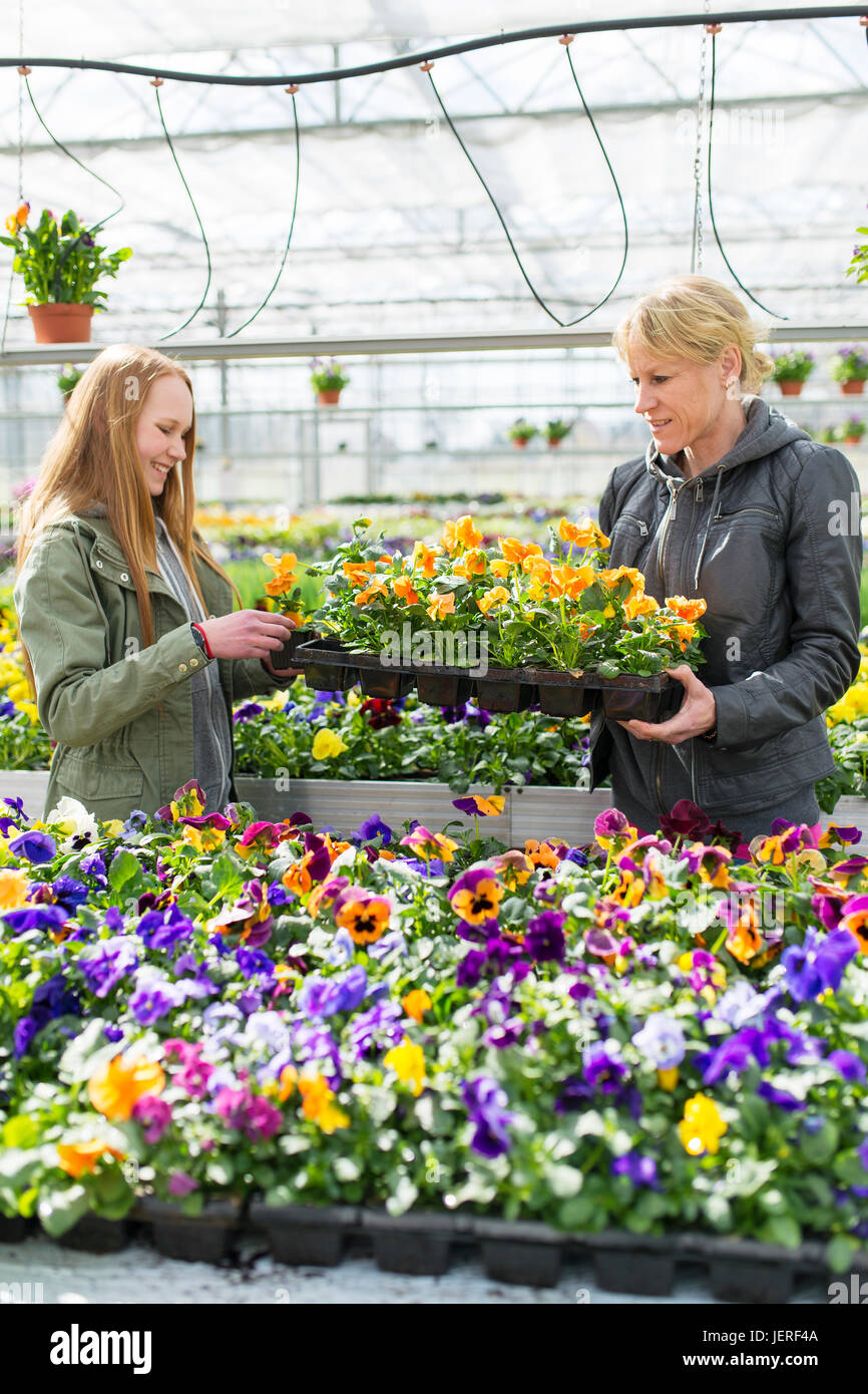 Mother with daughter choosing flowers in garden center Stock Photo