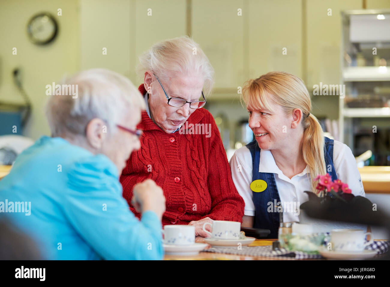Nurse in care home talking with senior patients Stock Photo