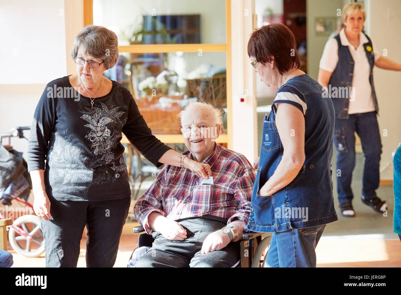 Nurses with smiling senior man in care home Stock Photo