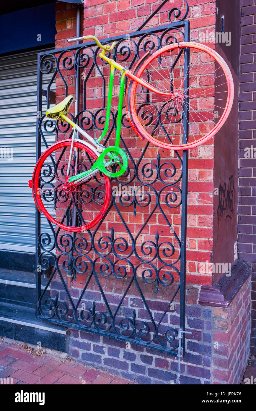 Multi-coloured bicycle hanging on a wrought iron gate in Adelaide, South Australia Stock Photo