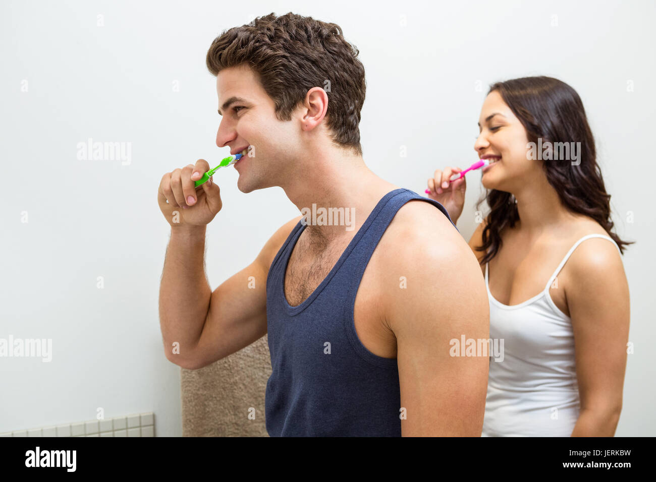 Couple brushing their teeth in bathroom Stock Photo