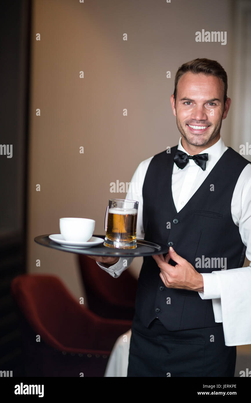 Waiter holding tray with beer Stock Photo - Alamy