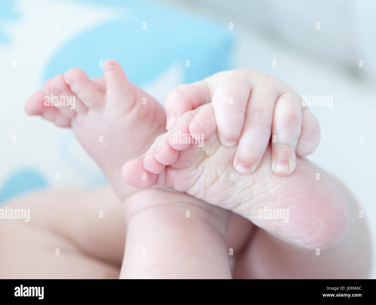 Closeup of babys hands holding feet Stock Photo Alamy