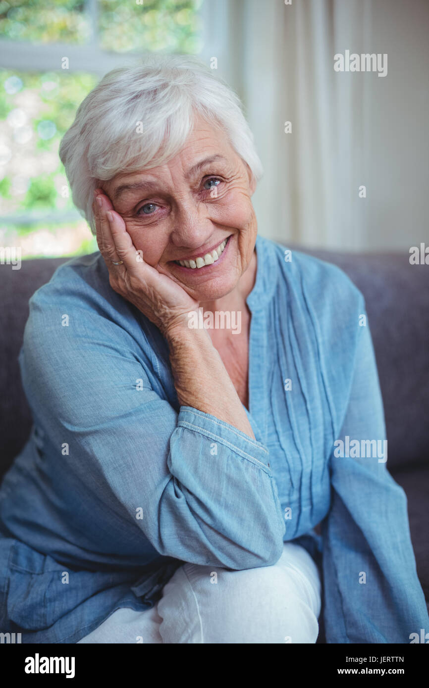 Happy senior woman sitting on sofa Stock Photo - Alamy