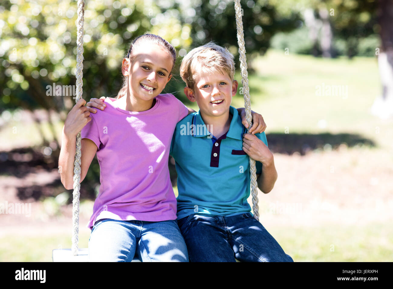Sister brother sitting in swing hi-res stock photography and images - Alamy