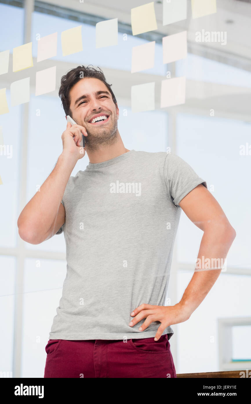Man talking on phone with hand on hip Stock Photo