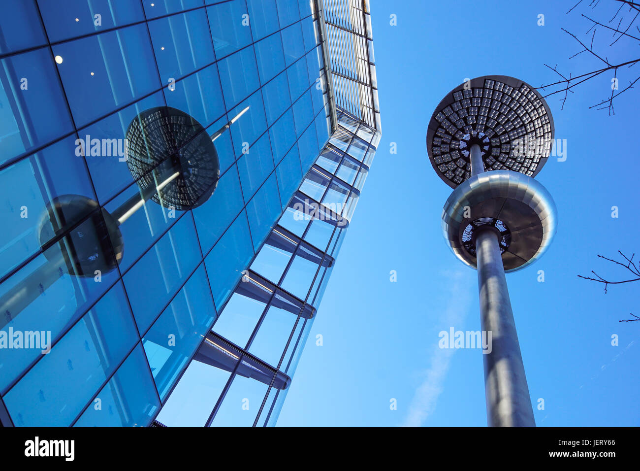 Lamp post in front of a Glass and concrete facade on a modern corporate skycraper building Stock Photo