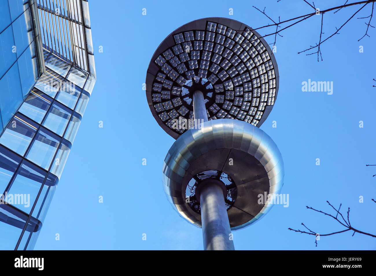 Lamp post in front of a Glass and concrete facade on a modern corporate skycraper building Stock Photo