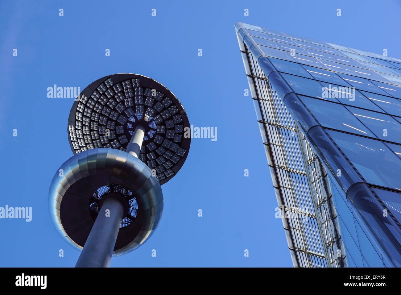 Lamp post in front of a Glass and concrete facade on a modern corporate skycraper building Stock Photo