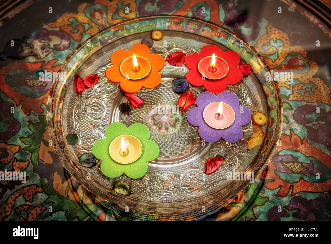 close up shot of floating colorful flower shaped candles in glass of bowl Stock Photo Alamy