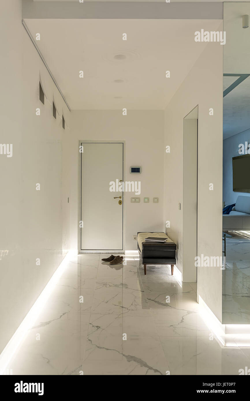 Hallway In A Modern Style With White Walls And A Light Tiled